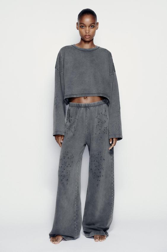 Image 1 of FADED-EFFECT RIPPED PLUSH TROUSERS from Zara